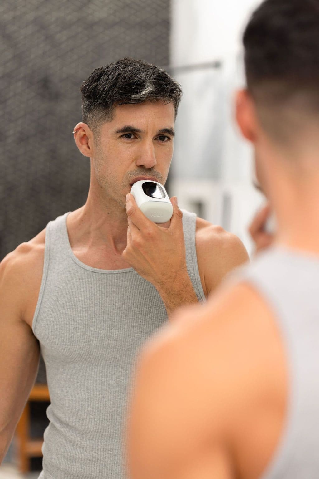 A person using the Feno smartbrush at the bathroom mirror as part of a morning routine